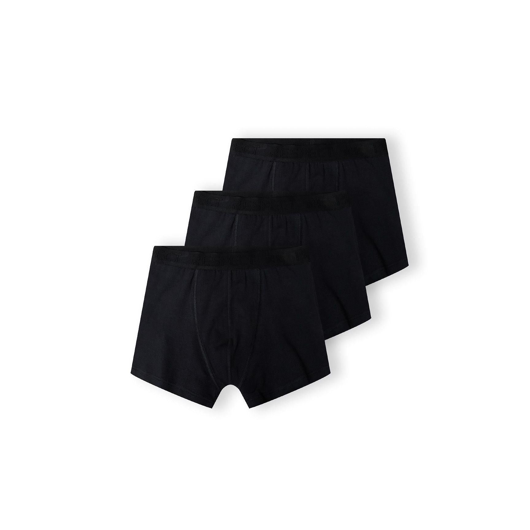 Three black boxer shorts arranged in overlapping stack on white background showing classic fit and construction