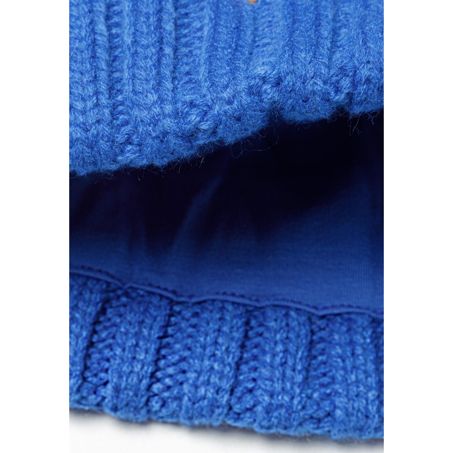 Interior detail showing soft fleece lining in navy blue and ribbed knit cuff construction of cobalt blue beanie
