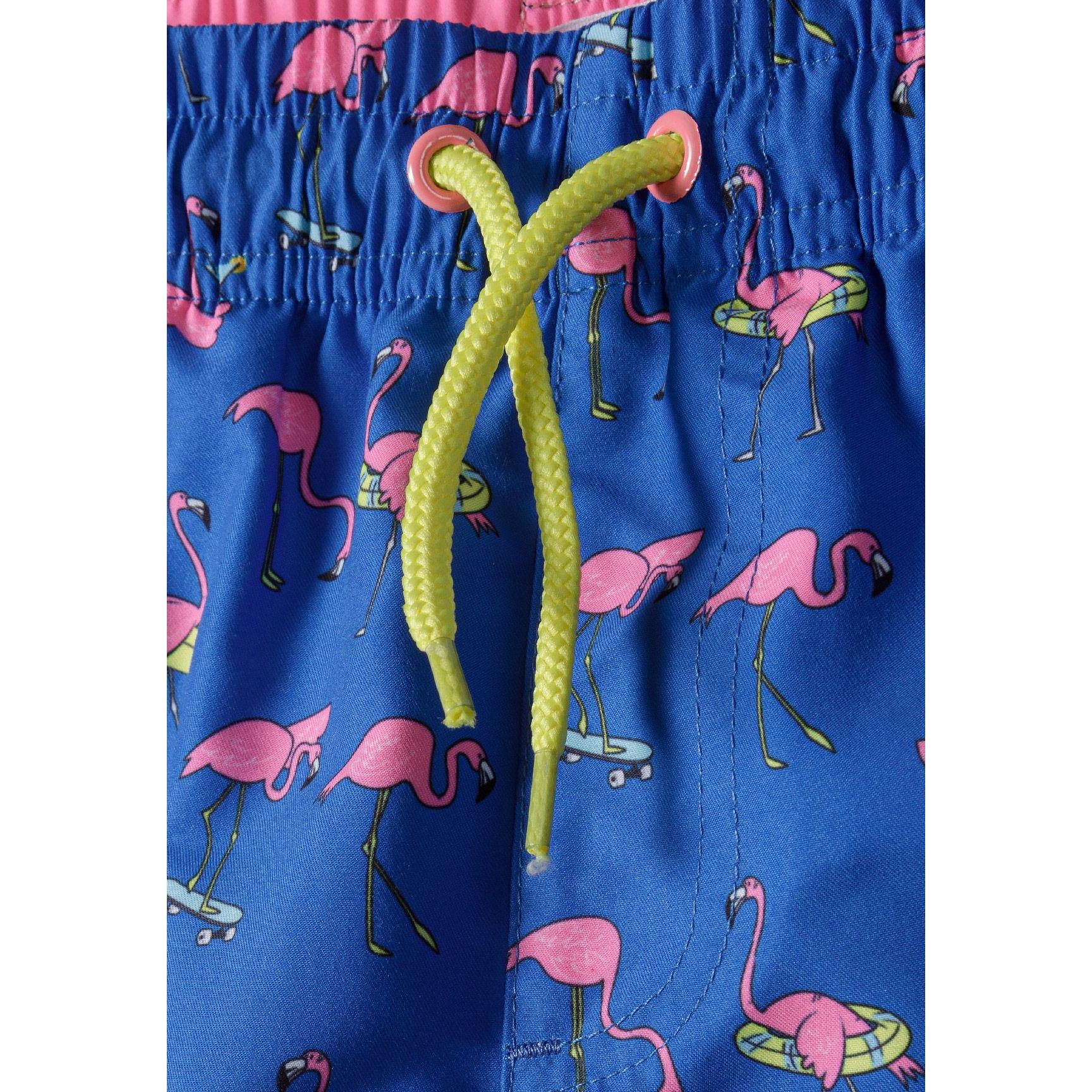 Close-up detail of cobalt blue board shorts waistband showing pink contrast trim, yellow drawstring and flamingo print pattern