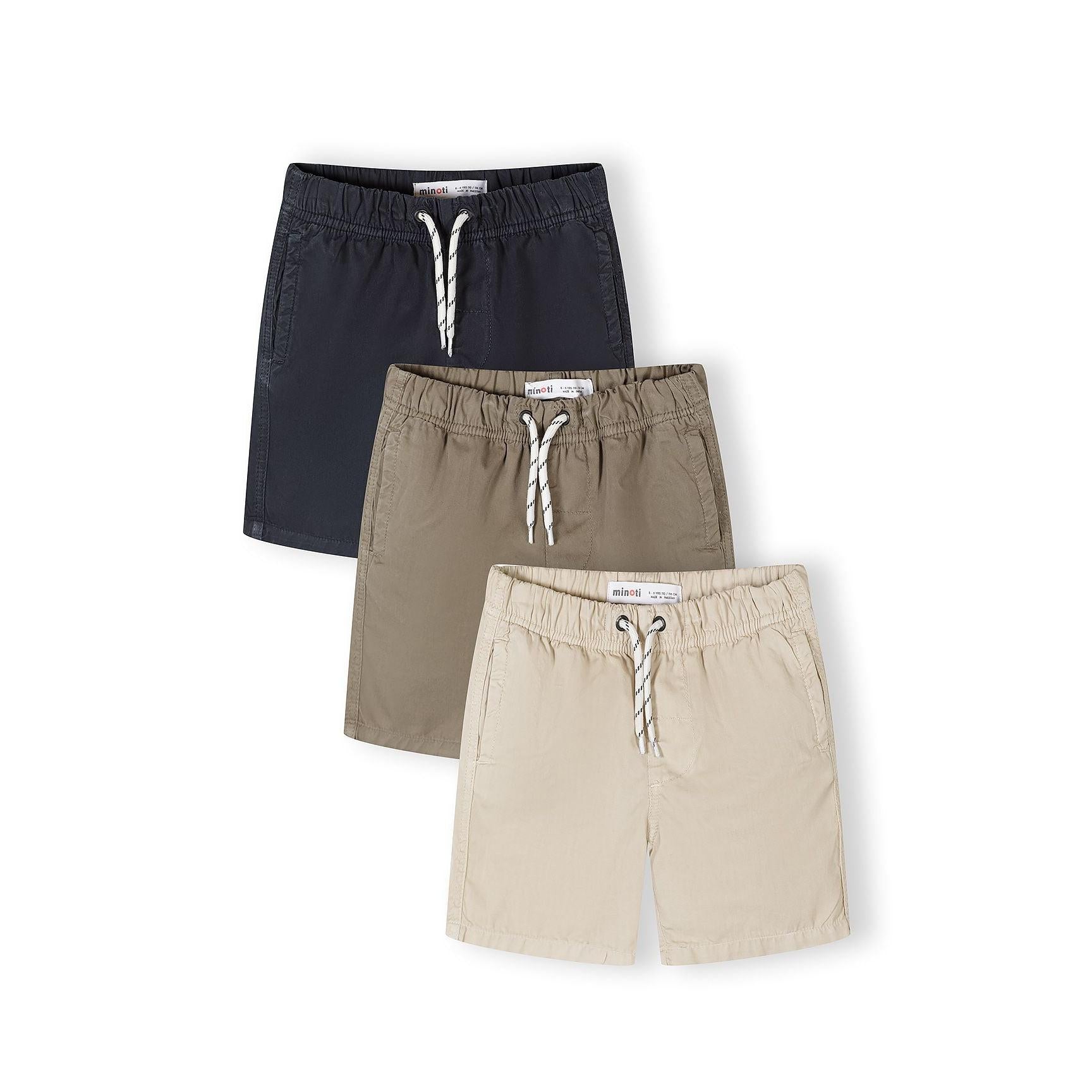 Three cotton shorts laid flat in olive green, beige and navy blue colours with rope drawstrings and Minoti labels visible on white background