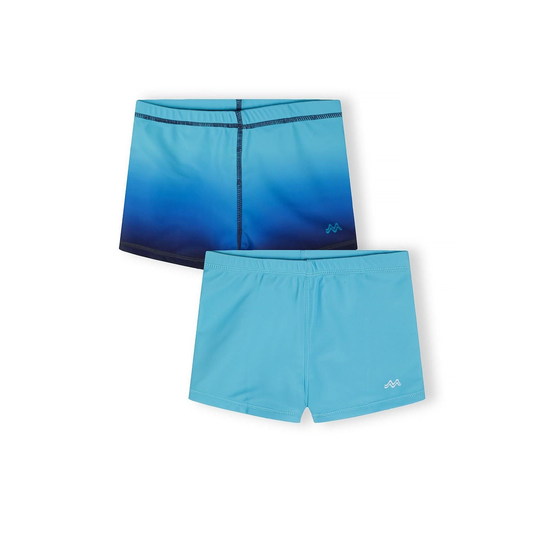 Two boys swim shorts displayed on white background - one in solid turquoise and one featuring blue to navy ombre gradient effect