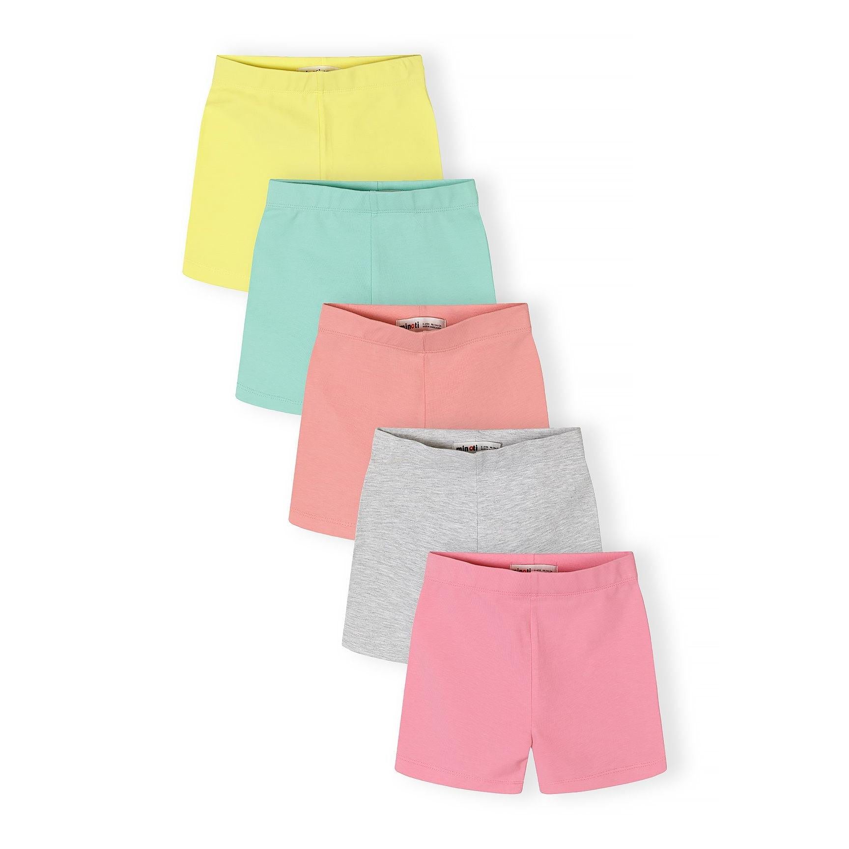 Five cycle shorts in pastel colours - yellow, mint green, coral pink, grey and bright pink - arranged in an overlapping fan display against white background