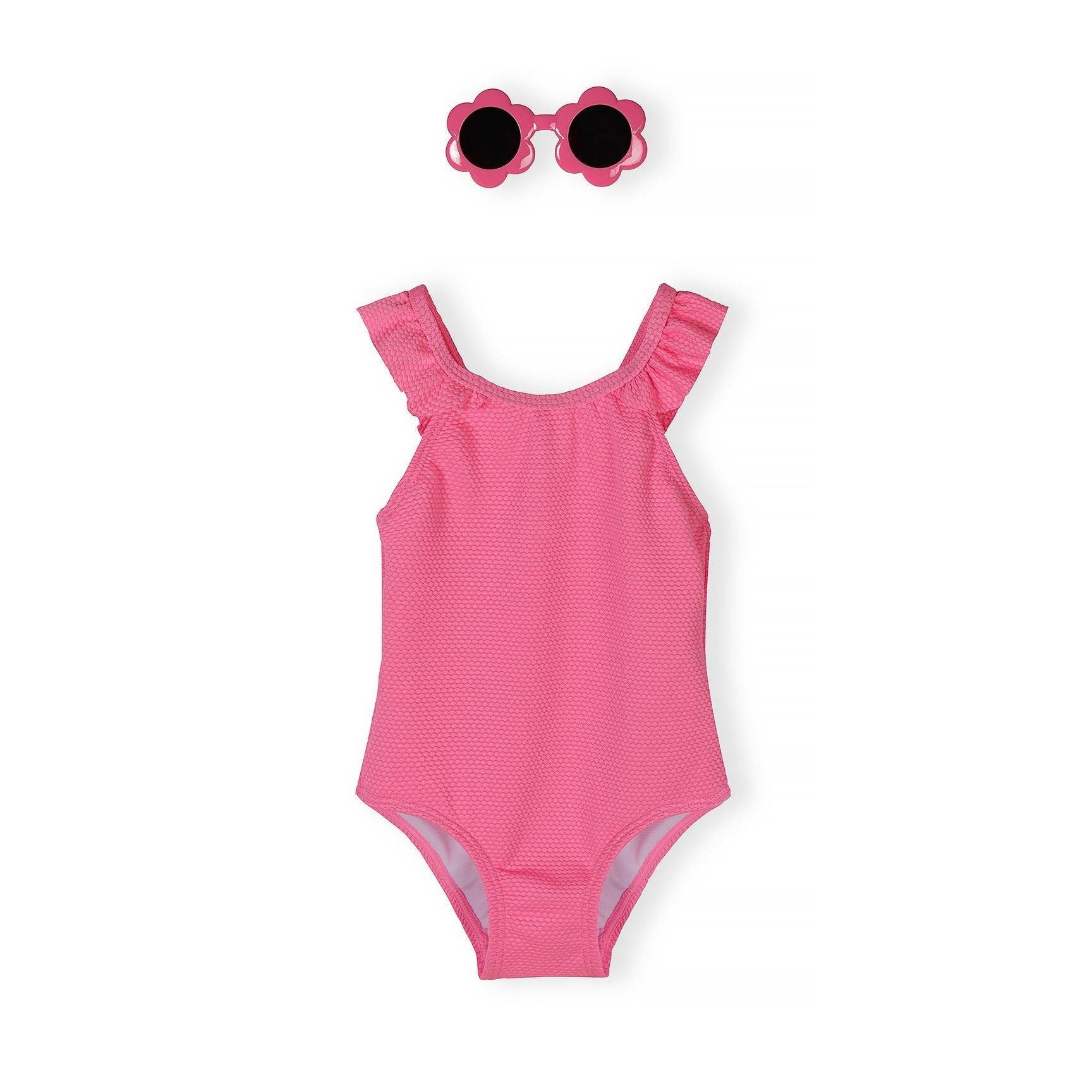 Neon pink girls swimsuit with frilled straps and flower-shaped sunglasses on white background