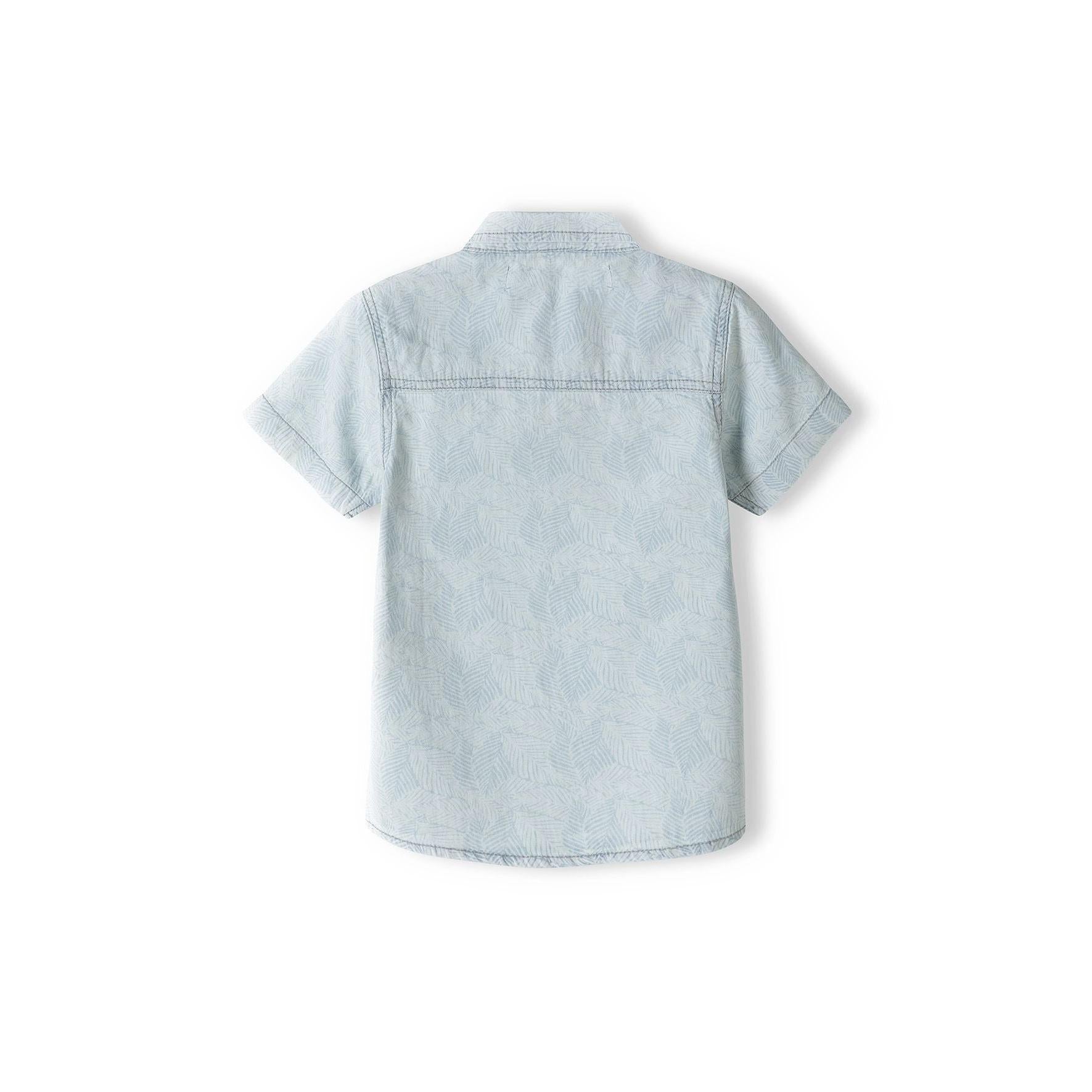 Close-up detail of light blue bleached denim shirt showing wooden-effect buttons, chest pocket stitching and collar construction