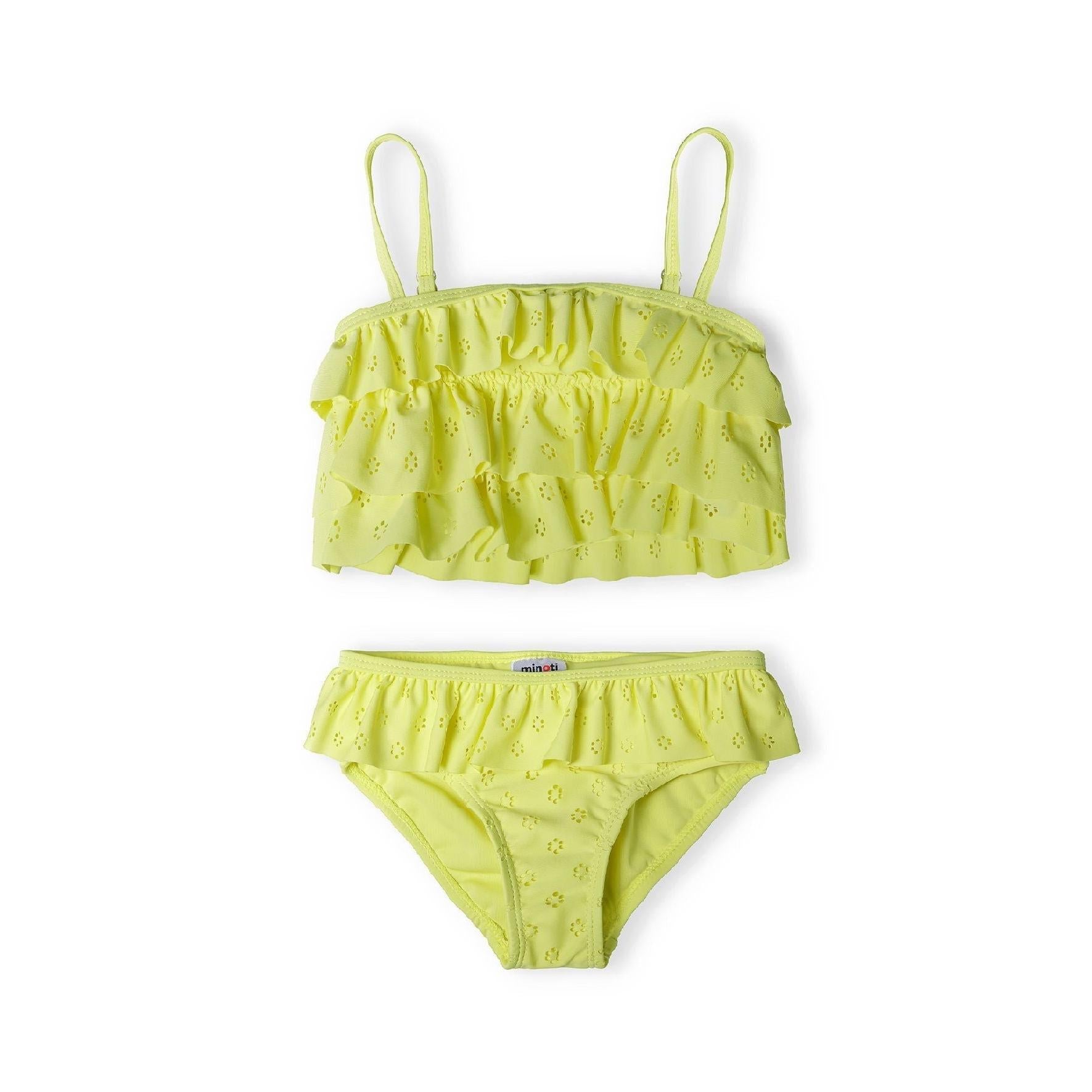 Yellow broderie anglaise bikini set laid flat on white background showing ruffle bandeau top with shoulder straps and matching high-waisted bottoms with frill waistband