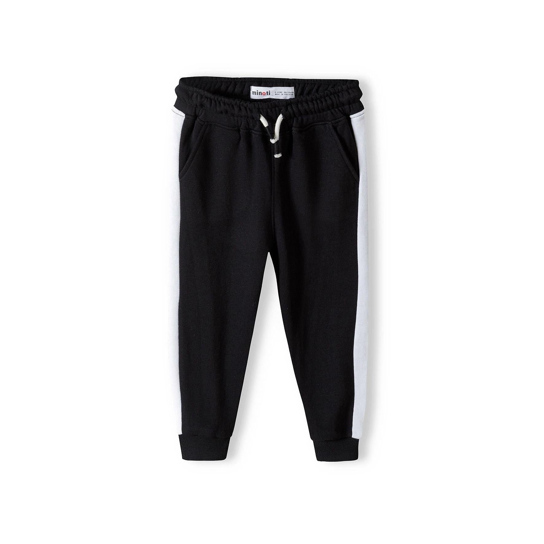 Black fleece joggers with white contrast stripes laid flat showing front view, elastic waist with drawstring, ribbed cuffs, Minoti label visible