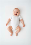 Baby short sleeve bodysuit with popper fastenings white 0-18m on a smiling infant, featuring a snug and flexible fit.