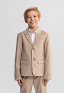 Young boy in a stone-colored formal blazer with tailored fit and classic lapels smiling confidently