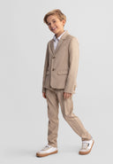 Young boy smiling wearing stone color suit trousers with an adjustable waistband in a smart casual design