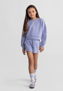 Young girl modeling stylish blue sweatshirt and shorts set with ribbed cuffs and elasticated waist in kids fashion style
