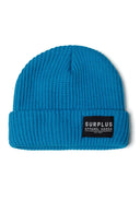 Close-up of a turquoise rib knit hat with a logo badge on the front.