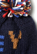 Close-up of a navy knitted hat featuring a multicolored pom pom and jacquard detail.