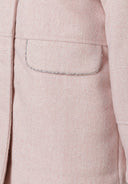 Detail of a girls padded jacket in pink with a pocket and herringbone pattern.