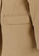 Detail of a beige girls' padded coat featuring a patch pocket.