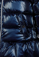 Detail of a girls padded jacket in navy with metallic shine, featuring a front zipper and pocket.