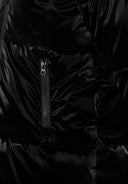 Detail of a girls' shiny black padded jacket featuring a zip pocket.