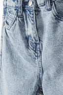 Detail of light blue ripped mom jeans with front pockets and button closure.