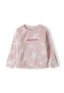 Girls pink pyjama top with raglan sleeves and star pattern, featuring 'DREAMER' embroidery, front view.