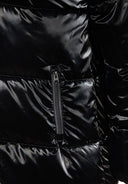 Close-up of a black puffer jacket featuring a zip pocket and glossy finish.