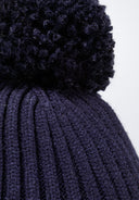 Close-up of a navy baby hat with a pom pom and ribbed texture.
