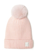 Close-up of a pink ribbed baby beanie with a pom pom and a subtle badge.