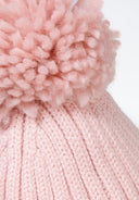 Detail of a pink knitted baby hat with a fluffy pom pom.