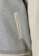 Girls baseball style jacket with faux leather sleeves grey 2-14y showing textured fabric and pocket detail close-up