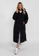 Women long black quilted winter jacket with drawstring hood, front view, featuring zipped pockets.