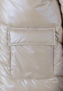 Detail of a quilted women's jacket showing a flap pocket.