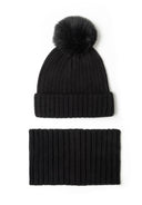 Black knitted beanie hat with faux fur pom pom and matching snood, front view.