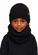Close-up of a black knitted beanie and snood set for boys, featuring ribbed texture and a logo badge.