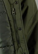 Detail of khaki men's baseball jacket showing zip and snap button closures.