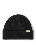 Close-up of a black ribbed beanie hat with a fold-up cuff and a discreet badge.
