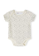 Girls short sleeve bodysuit in cream with black dots, close-up view.