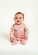 Detail of a pink long-sleeve sleepsuit with animal prints and integrated feet.