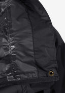 Detail of a black waterproof jacket showing the hidden hood and zip fastening.