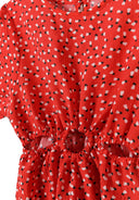 Detail of a girls' red short sleeve dress featuring waist cut-outs and ruffled sleeves.