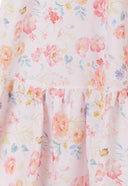 Detail of a tiered pink girls dress with floral print and ruffled shoulder straps.