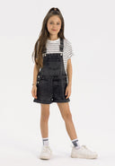 Girls short black denim dungarees with adjustable braces, front pockets, and button fastenings.