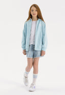 Girls oversized zip-through hoodie in light blue, front view with hood and front pocket.