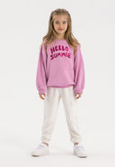 Girls white fleece cargo joggers with side pockets, front view.