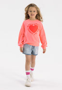 Girls coral fleece crew neck sweatshirt with decorative print, front view.