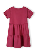 Back view of a pink girls' dress with a tiered hem and short sleeves.