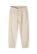 Detail of beige joggers with elasticated waistband and side pockets.