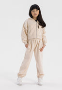 Cropped beige hoodie with zip and matching joggers, featuring side pockets and ribbed cuffs.