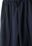Detail of jogger trousers with elasticated waistband and side pocket.