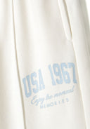 Detail of cream cropped hoodie with blue printed text and kangaroo pocket.