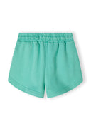 Detail of green girls' shorts with elasticated waistband and rounded edges.