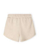 Detail of beige shorts with elasticated waistband and rounded edges.