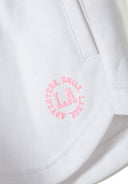 Detail of white girls' hoodie with pink printed logo and side pocket.